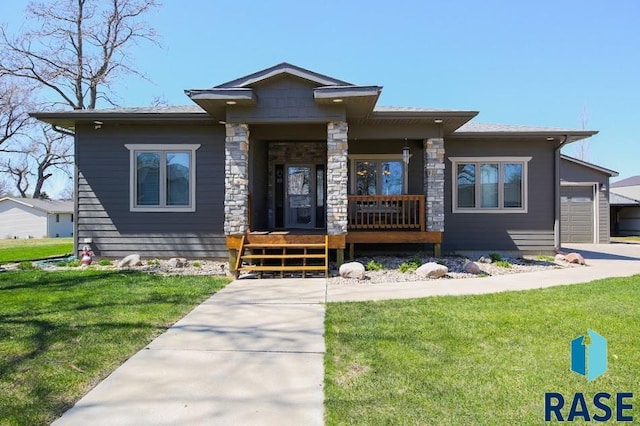 105 N Nora St, Viborg, SD 57070 - prairie-style home featuring a front lawn, stone siding, covered porch, and a garage