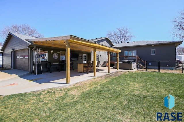 105 N Nora St, Viborg, SD 57070 - back of property with a hot tub, a lawn, a patio, fence, and an attached garage