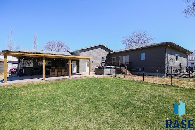 105 N Nora St, Viborg, SD 57070 - back of property featuring a hot tub, a patio area, a lawn, fence, and outdoor dry bar