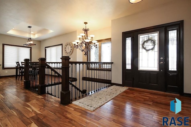 105 N Nora St, Viborg, SD 57070 - foyer entrance with baseboards, a raised ceiling, an inviting chandelier, and hardwood / wood-style flooring