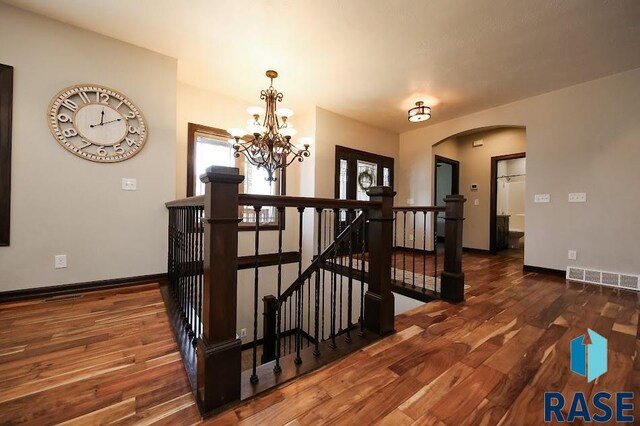 105 N Nora St, Viborg, SD 57070 - staircase with visible vents, baseboards, an inviting chandelier, and wood finished floors