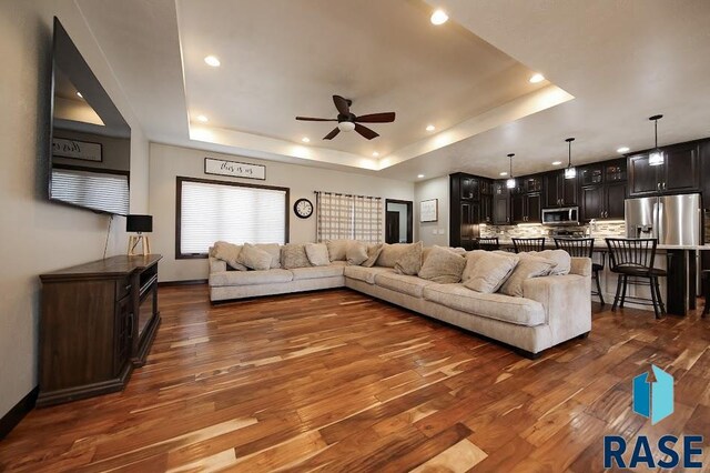 105 N Nora St, Viborg, SD 57070 - living area with ceiling fan, dark wood-type flooring, recessed lighting, a raised ceiling, and baseboards