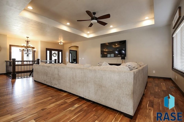 105 N Nora St, Viborg, SD 57070 - living area with ceiling fan with notable chandelier, dark wood-type flooring, arched walkways, a raised ceiling, and plenty of natural light