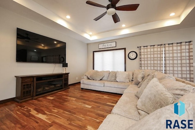 105 N Nora St, Viborg, SD 57070 - living room featuring a raised ceiling, baseboards, wood finished floors, and ceiling fan