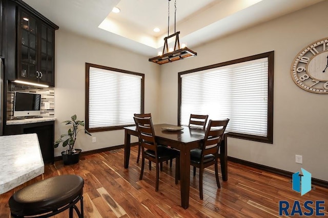 105 N Nora St, Viborg, SD 57070 - dining area with recessed lighting, dark wood-style flooring, baseboards, and a raised ceiling