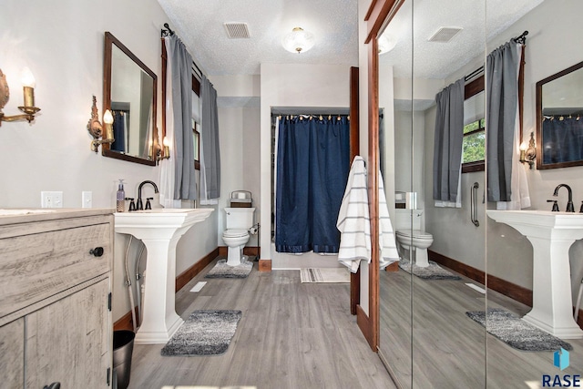28128 462nd Ave, Davis, SD 57021 - full bathroom with toilet, wood finished floors, baseboards, and visible vents