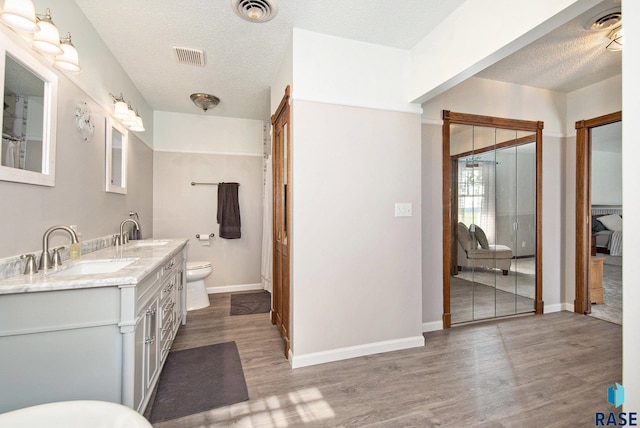 28128 462nd Ave, Davis, SD 57021 - bathroom featuring a textured ceiling, wood finished floors, a sink, and visible vents