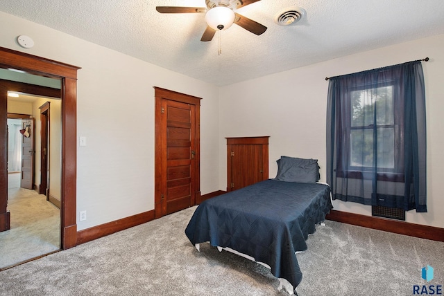 28128 462nd Ave, Davis, SD 57021 - bedroom with baseboards, a textured ceiling, carpet floors, visible vents, and ceiling fan