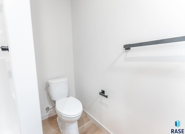 bathroom featuring baseboards, toilet, and wood finished floors
