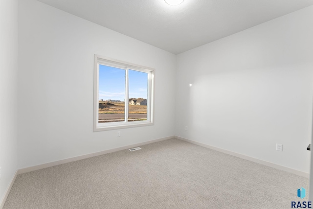 carpeted empty room with visible vents and baseboards