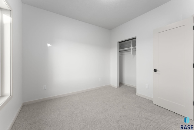 unfurnished bedroom featuring a closet, carpet, and baseboards