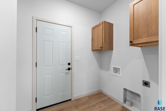laundry area featuring baseboards, light wood-type flooring, hookup for an electric dryer, cabinet space, and hookup for a washing machine
