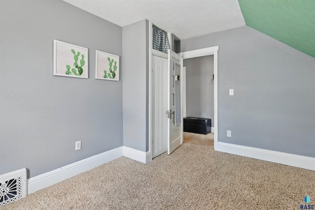 interior space with vaulted ceiling, baseboards, carpet flooring, and visible vents