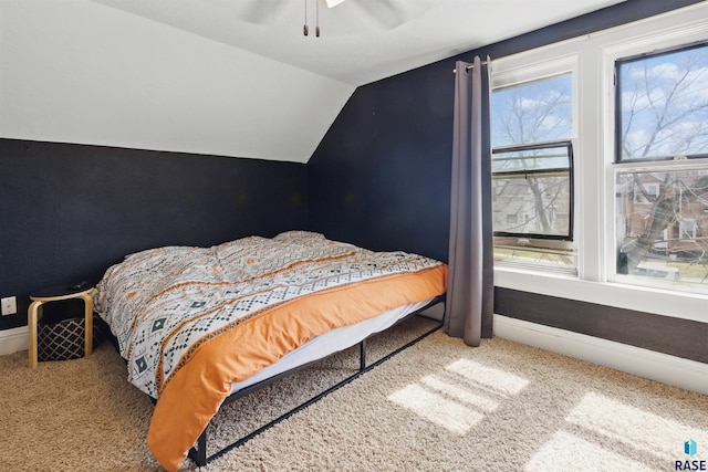 carpeted bedroom with a ceiling fan, baseboards, and vaulted ceiling