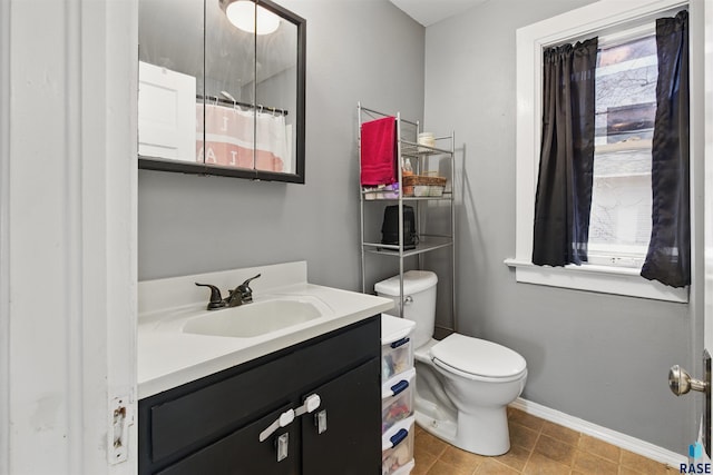 full bathroom with toilet, baseboards, tile patterned floors, and vanity