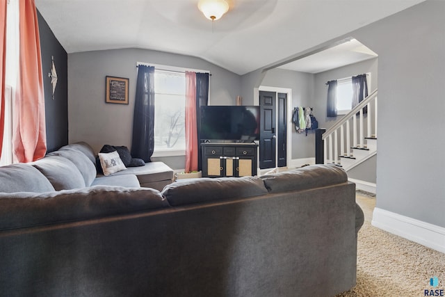 carpeted living area featuring baseboards, a ceiling fan, stairs, and lofted ceiling