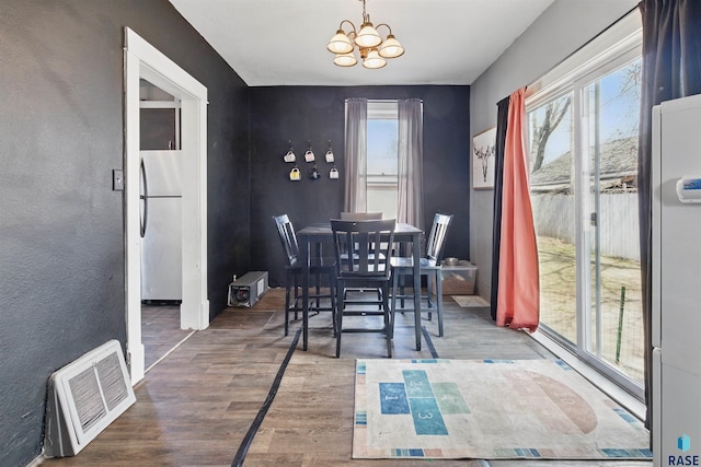 dining space featuring a notable chandelier, wood finished floors, and visible vents
