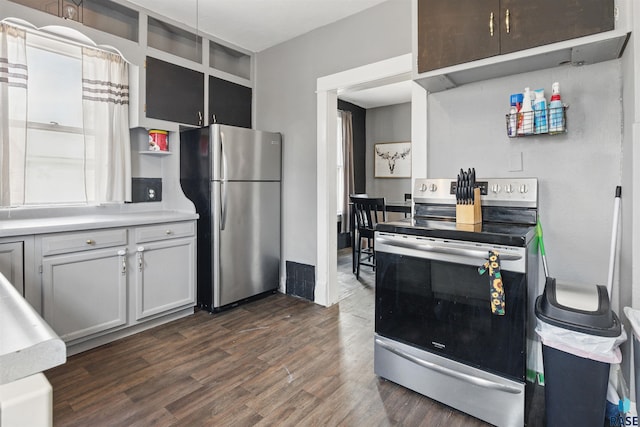 kitchen with dark wood-style flooring, stainless steel appliances, open shelves, and light countertops
