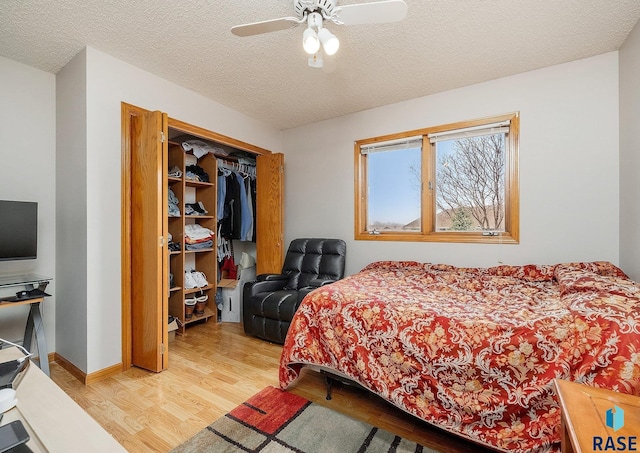 bedroom with light wood-style flooring, a closet, a textured ceiling, and ceiling fan