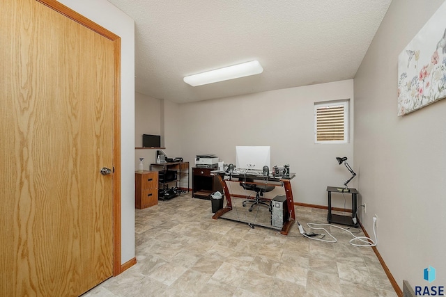 office area featuring stone finish floors, baseboards, and a textured ceiling