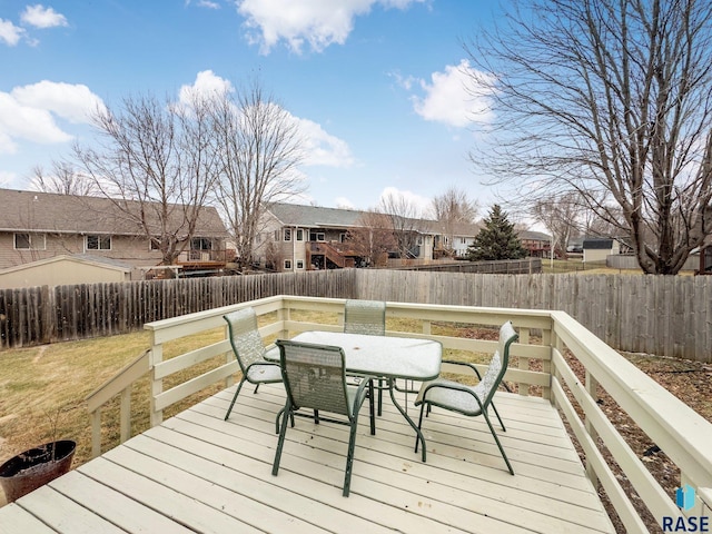 wooden deck with a residential view and outdoor dining space