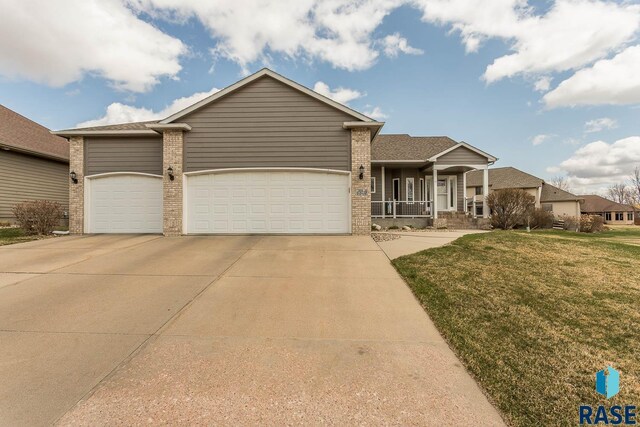 6520 S Heatherridge Trl, Sioux Falls, SD 57108 - single story home with concrete driveway, a front lawn, an attached garage, a porch, and brick siding