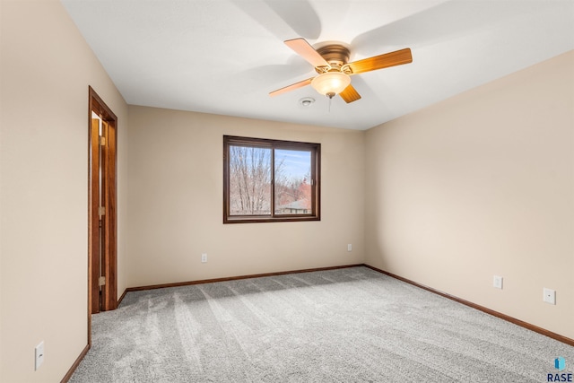 carpeted empty room featuring ceiling fan and baseboards