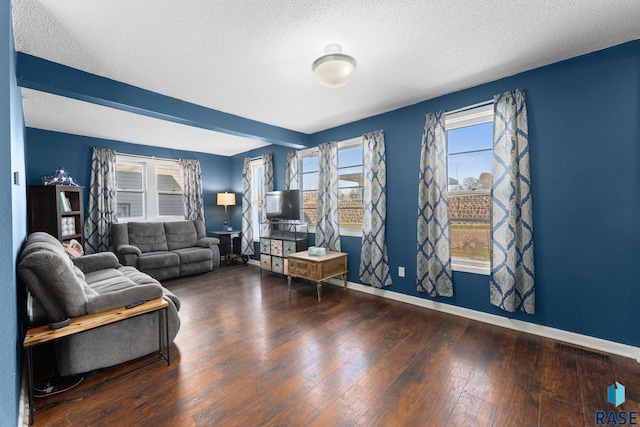 living area with wood-type flooring, a textured ceiling, and baseboards