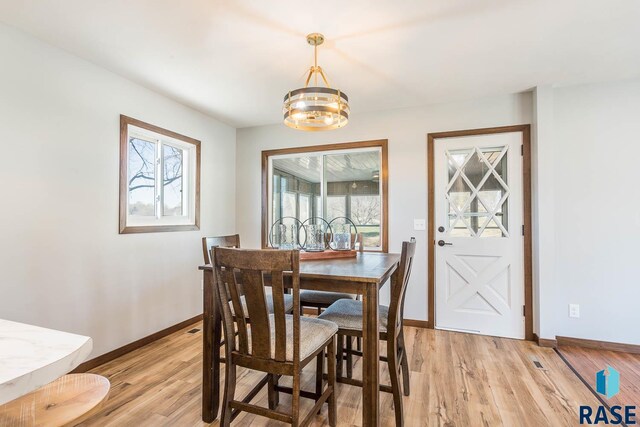 1000 N Six Mile Rd, Sioux Falls, SD 57110 - dining room featuring light wood-style flooring, a chandelier, and baseboards