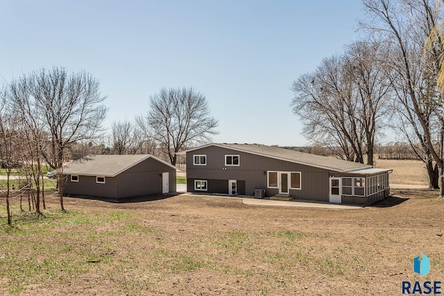 1000 N Six Mile Rd, Sioux Falls, SD 57110 - back of property with a sunroom, an outbuilding, a detached garage, and central AC unit