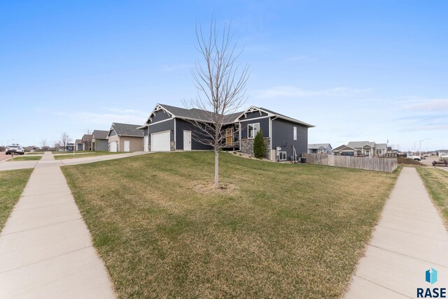 5320 S Solono Ave, Sioux Falls, SD 57108 - view of front of home with a garage, a front yard, stone siding, fence, and concrete driveway