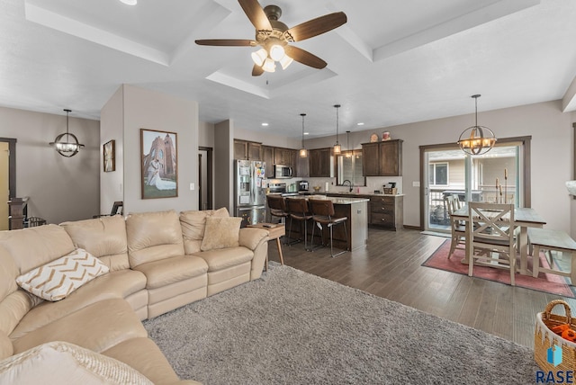 5320 S Solono Ave, Sioux Falls, SD 57108 - living area featuring dark wood-style flooring, recessed lighting, beamed ceiling, coffered ceiling, and ceiling fan with notable chandelier