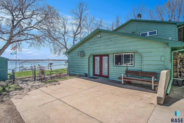 rear view of property with a patio, french doors, fence, and a gate