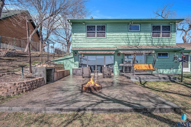 rear view of house featuring a patio, a fire pit, and fence