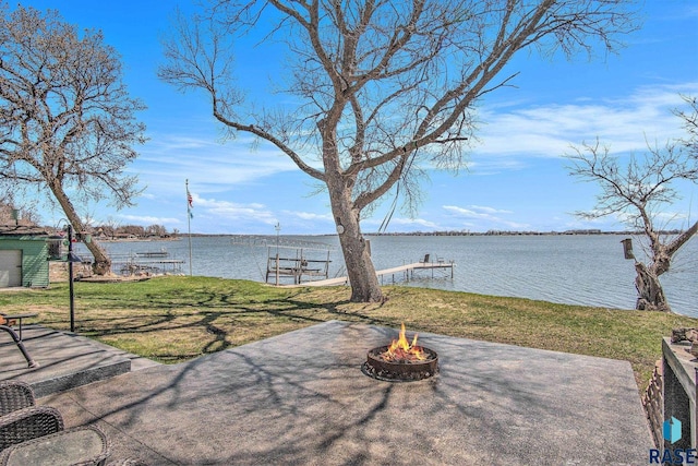 exterior space with a water view, a boat dock, and an outdoor fire pit