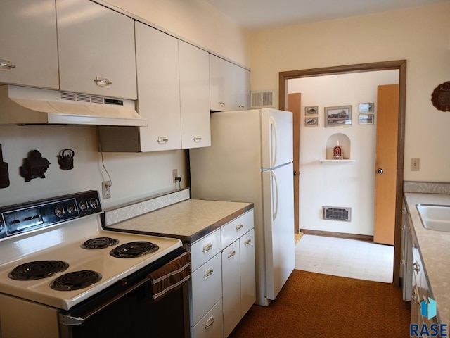kitchen with freestanding refrigerator, electric range, visible vents, under cabinet range hood, and a sink