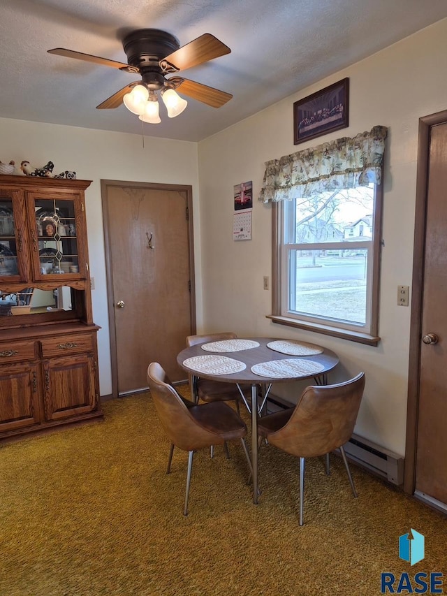 dining area with a ceiling fan, a baseboard heating unit, and carpet flooring