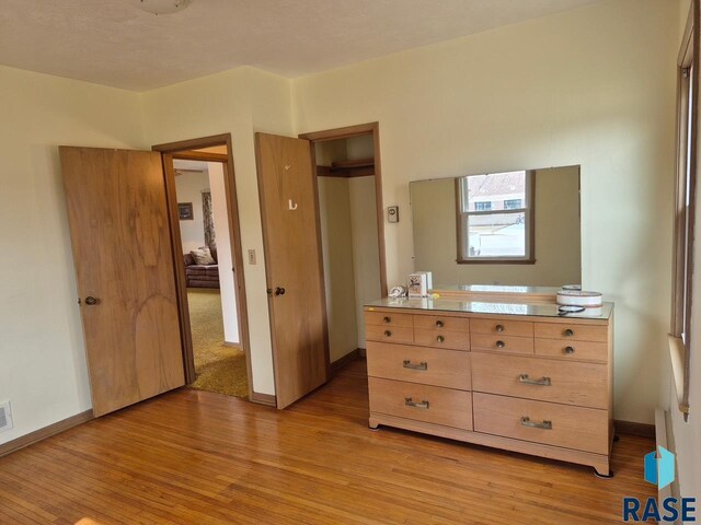 bedroom with light wood-style flooring, baseboards, and visible vents