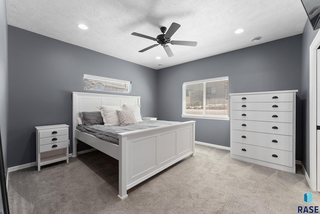 bedroom with baseboards, a textured ceiling, recessed lighting, and light colored carpet