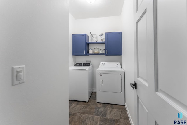washroom featuring separate washer and dryer, baseboards, and cabinet space