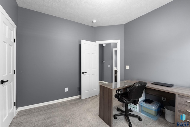 office area with carpet floors, a textured ceiling, and baseboards