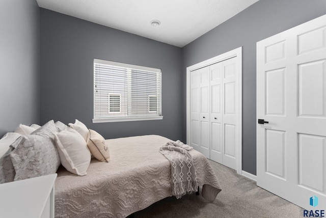 carpeted bedroom with baseboards and a closet