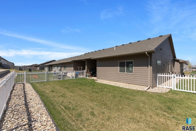 back of property with a fenced backyard and a yard