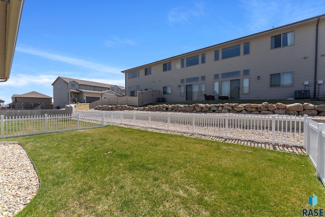 view of yard with a fenced backyard and central air condition unit