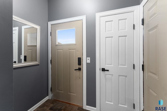 entryway featuring baseboards and dark wood-style floors