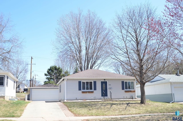 ranch-style house featuring roof with shingles, an outbuilding, a detached garage, and a front yard