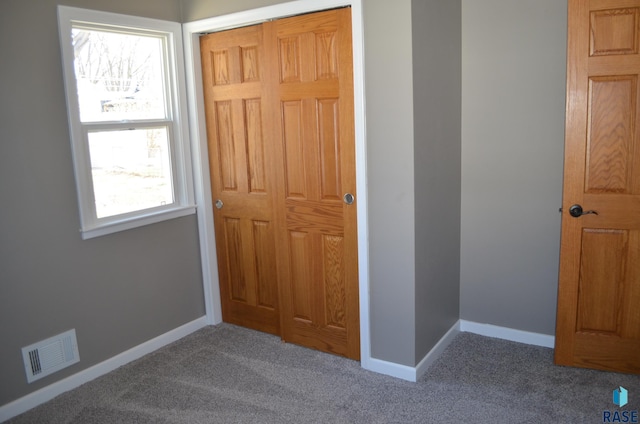interior space featuring baseboards, visible vents, and carpet flooring