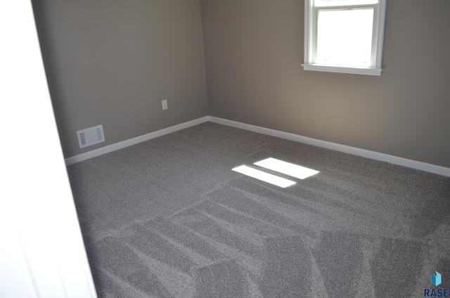carpeted spare room with baseboards and visible vents