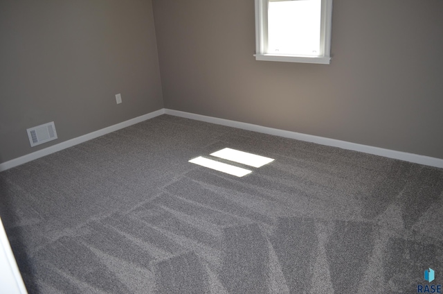 carpeted spare room featuring baseboards and visible vents