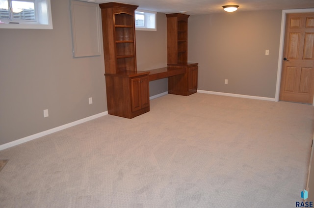 basement with baseboards and light colored carpet